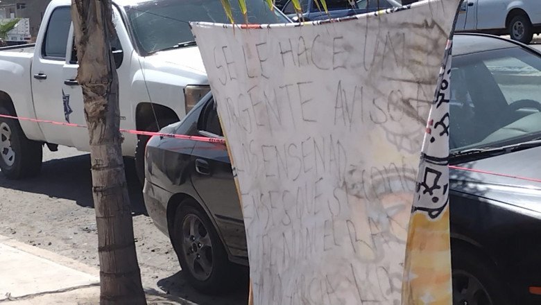 Cuelgan manta con amenazas en vía pública